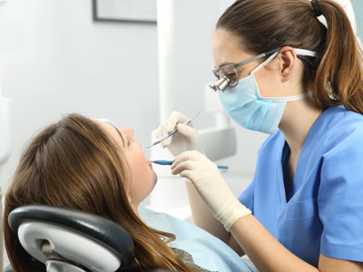 A dental hygienist is assisting a patient during a teeth cleaning appointment.