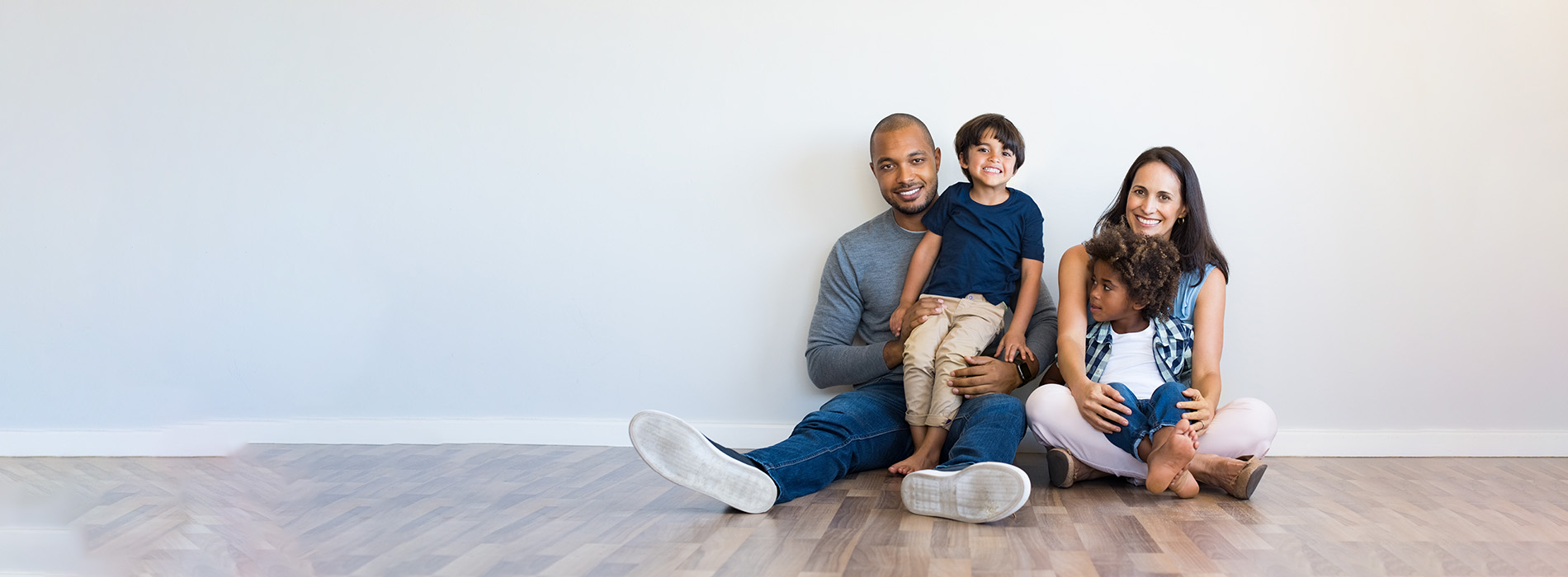 A family of three, including two adults and a child, posing together in a home setting.